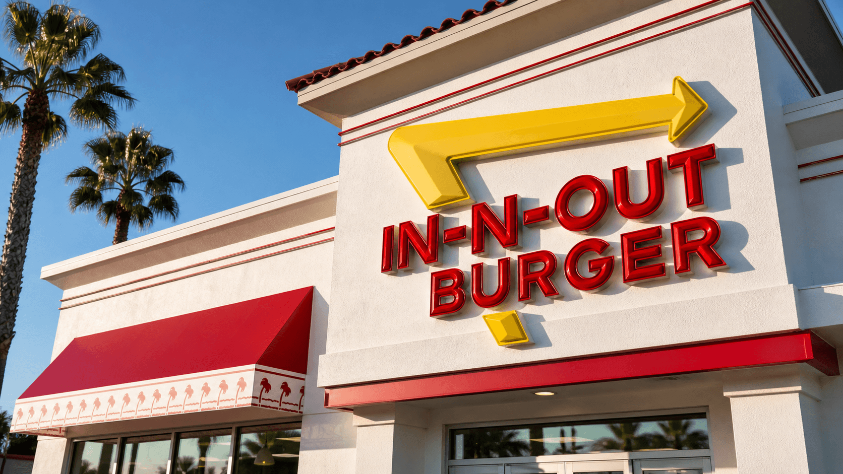 A close-up of an In-N-Out Burger sign outside a modern restaurant storefront