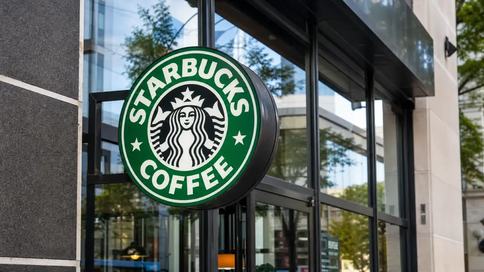 A close-up of a Starbucks Coffee sign outside a modern cafe storefront